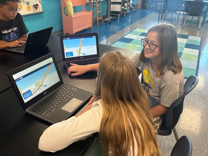 Third graders comparing roller coaster designs in the Qweebi online makerspace.