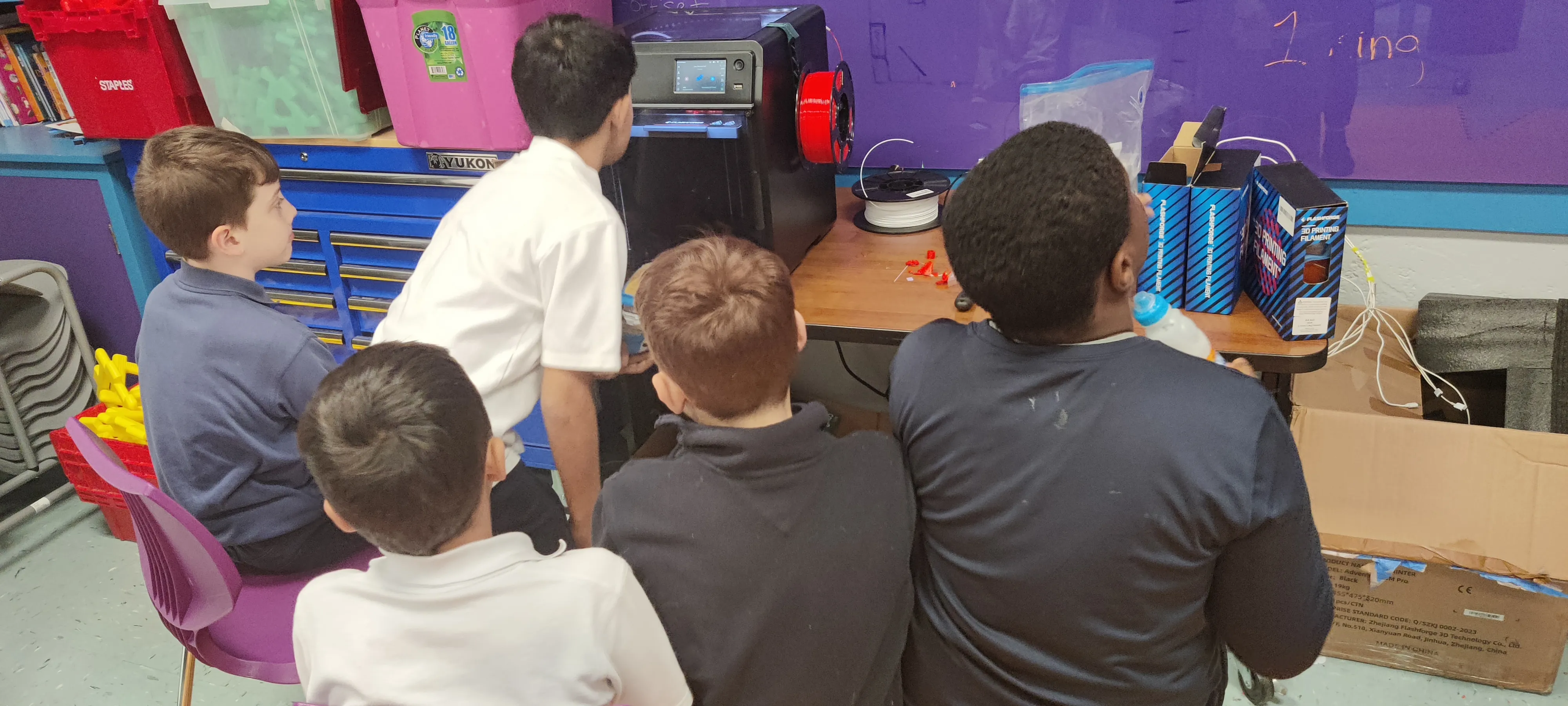 Students watching a 3D printer Kim Smith negotiated for her classroom.
