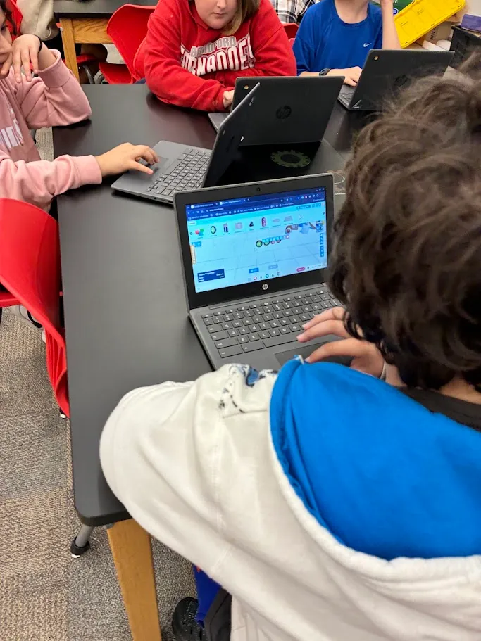 A student recording a show-and-tell video of their Qweebi project.