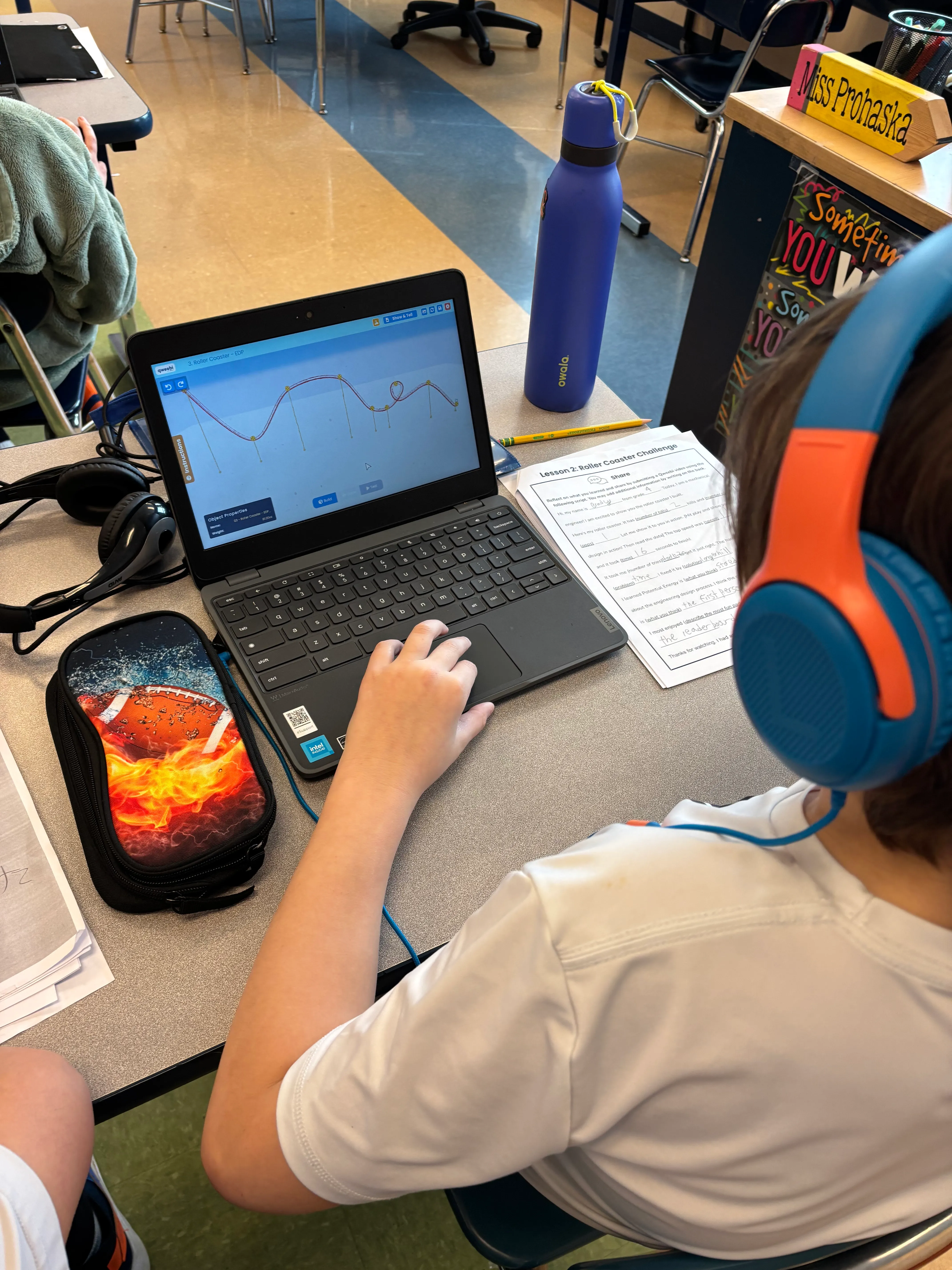 A student wearing headphones while working in the Qweebi online makerspace.