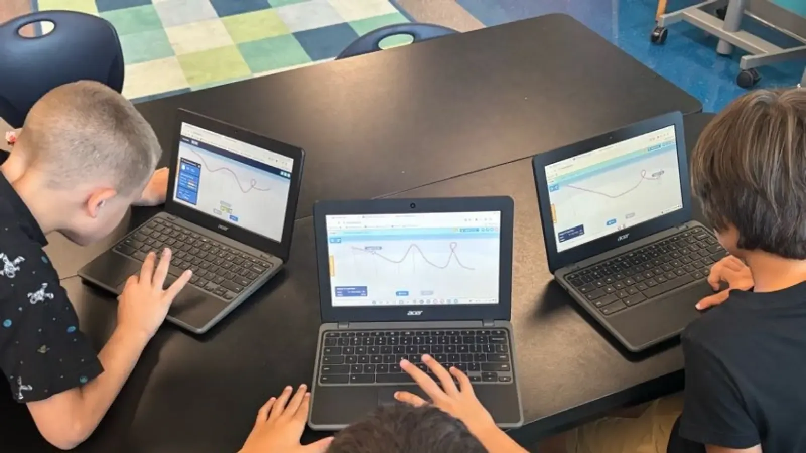 A teacher introducing a Qweebi project to her class on the classroom screen.